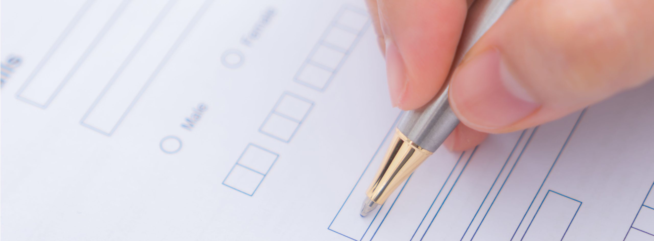 Hand with pen over application form
